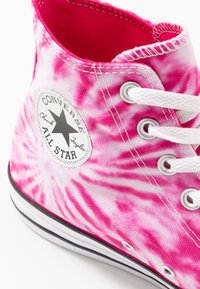 Růžovo-bílé batikované vysoké tenisky Converse Chuck Taylor All Star s bílými tkaničkami a černým pruhem na podrážce.