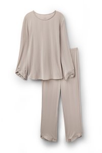 Lichtbeige lounge-set gemaakt van zachte stof, bestaande uit een langmouwtop met horizontale strepen en bijpassende losse broek.