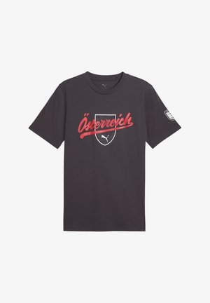 Sort Puma t-shirt med rød "Österreich" tekst på tværs af et hvidt skjold og Puma logo, samt et rundt mærke på højre ærme.