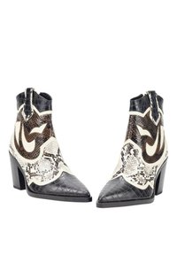 Botines en blanco y negro con punta afilada, texturas de serpiente y cocodrilo, y un diseño curvado con un logotipo prominente en la parte superior.