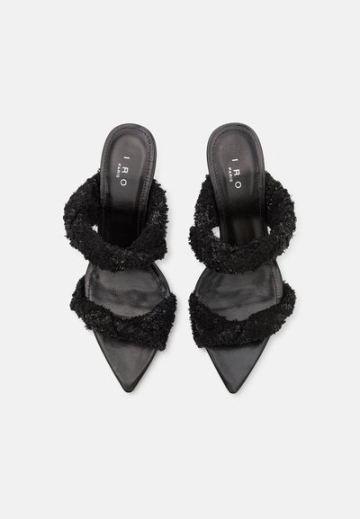 Sorte hælede sandaler med spidse tåer, der har teksturerede fuzzy stropper og en glat læderindersål. Enkel, minimalistisk design.