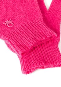Jasně růžové pletené rukavice s vroubkovanými manžetami a malou růžovou nášivkou. Měkká textura a tvar ruky pro teplo a pohodlí.