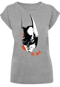 Pelēka T-kreklu ar melnbaltu Batman grafiku, ar oranžiem plankumiem, īsām sarullētām piedurknēm un brīvu piegriezumu.