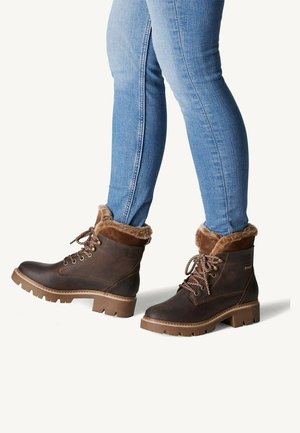 Bottes de cheville marron imperméables avec doublure en fausse fourrure, semelle robuste et laçage à l'avant. Cuir texturé avec une semelle extérieure en caoutchouc contrastante.