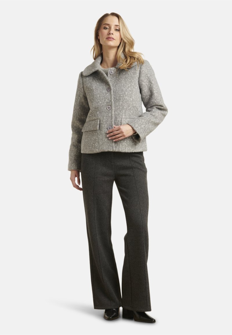 Gray wool-blend jacket with a collar, three buttons, and two front pockets, paired with high-waisted dark gray flared pants and black shoes.