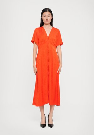 Vestido midi rojo con escote en V, mangas cortas y detalles de botones frontales. Confeccionado en tela texturizada con una silueta elegante y fluida.