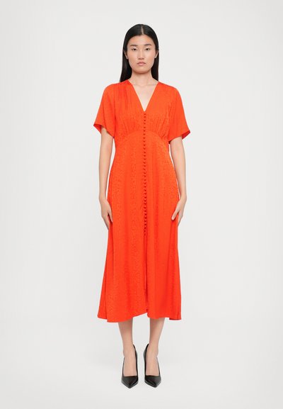 Red midi dress with a V-neck, short sleeves, and front button detailing. Made of textured fabric with a sleek, flowy silhouette.