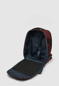 Donkerrode rugzak met een marineblauwe binnenkant, voorzien van verstelbare banden en een platte bodem. Geen zichtbare uitwendige zakken.