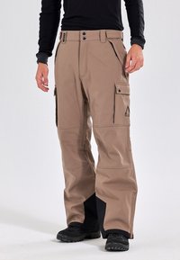 Beige cargobroek gemaakt van duurzaam materiaal, met meerdere zakken, een ritszak aan de zijkant en zwarte accenten aan de manchetten.