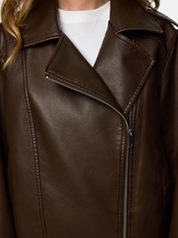 Καφέ δερμάτινο μπουφάν μηχανής με διαγώνιο φερμουάρ, γιακά με εγκοπές, υφασμένη επιφάνεια και ορατές λεπτομέρειες ραφής.