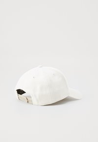 Cappellino da baseball in tessuto bianco con visiera curva, cinturino regolabile sul retro e fori di ventilazione, caratterizzato da una texture liscia e un design semplice.