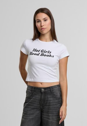 Witte cropped t-shirt met "Hot Girls Read Books" in vetgedrukt zwart lettertype. Gecombineerd met donkergrijze denim jeans. Soepele textuur, korte mouwen.