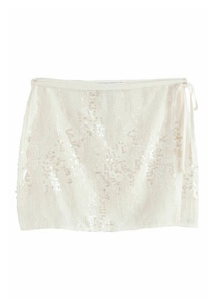Mini-jupe blanche avec un nouage latéral présentant un motif de sequins brillants pour un effet scintillant.