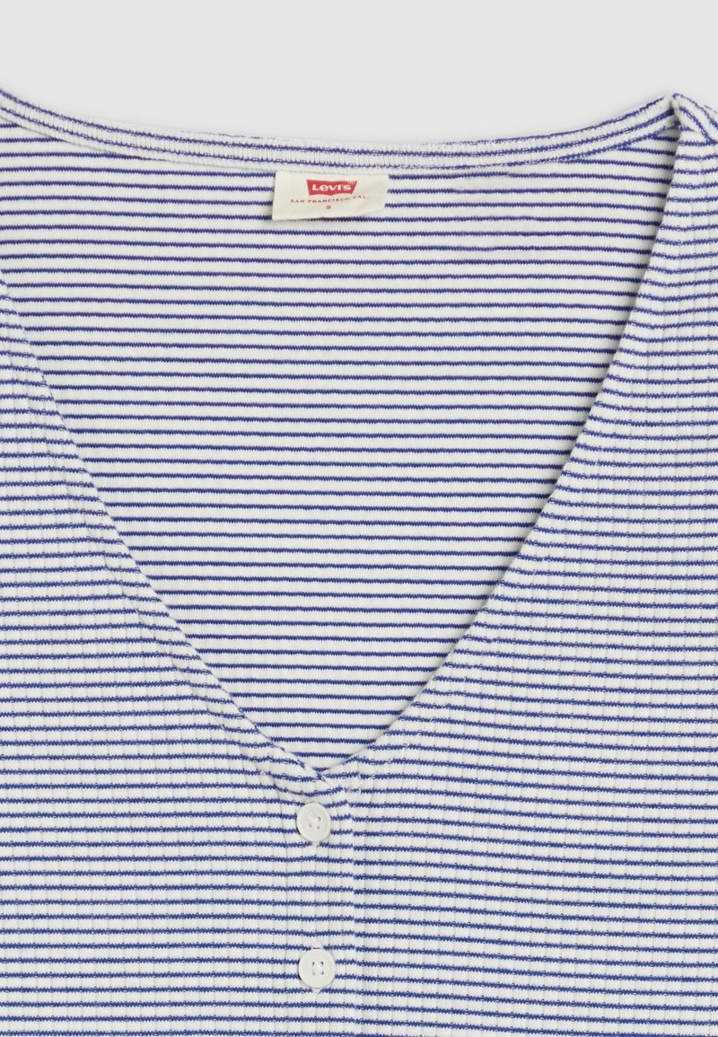 T-shirt rayé en coton blanc et bleu marine. Décolleté en V avec trois boutons blancs à l'avant ; tissu doux et texturé. Étiquette visible.