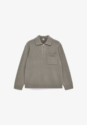 Sweater in muted beige, made of textured knit material, featuring a collar, half-zip front, and a small chest pocket.