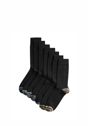 Siedem par czarnych skarpetek ułożonych w rząd, każda z innym kolorowym paskiem na palcach i pięcie.