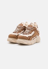 Sneakers in suede beige con dettagli in pelliccia finta bianca, dotati di suole in gomma spesse e lacci con texture a contrasto. Logo sul lato e sulla linguetta.