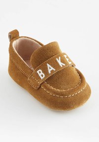 Hnedé semišové detské loafers s prešitým bielym pásikom s nápisom "BAKE" na prednej strane a s obložením na päte pre ľahké obúvanie. Mäkčené vnútorné podšívky.