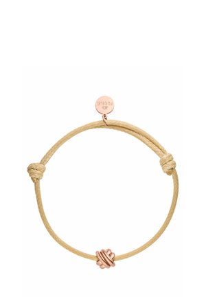 Bracelet en cordon tressé beige avec un design noué et une étiquette en métal rose gold, présentant un détail de charme circulaire.