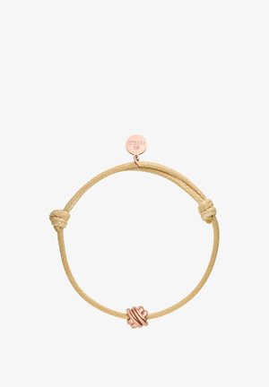 Geflochtener beiger Schnurarmband mit einem geknoteten Design und einem roségoldenen Metallakzent-Tag, das über ein kreisförmiges Charm-Detail verfügt.