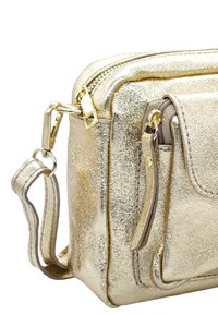 Sac à main métallique doré avec surface texturée, forme rectangulaire élégante, fermeture éclair, bandoulière amovible et détail de poche avant.