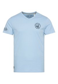 Camiseta de algodón azul claro con escote en forma de V, que presenta un gráfico circular con velas en la parte delantera y texto en la manga y el dobladillo.