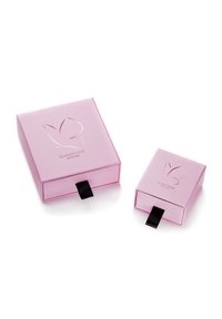 Divas divas rozā taisnstūra kastītes ar glancētu apdari. Katrai ir reliefs tauriņa logo un melna lentīte, kas atvieglo atvēršanu.