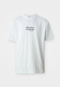 Vit bomull t-shirt med texten "the new originals jazz club" i blått. Korta ärmar och design med rund hals. Slät textur.