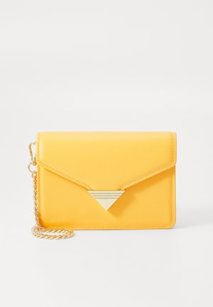 Kollane kunstnahast kott ümbrikukujulise disainiga, millel on kolmnurkne kuldne metallaktsent ja kuldne kett.
