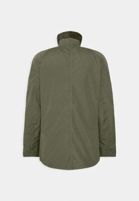 Oliwkowa kurtka z wysokim kołnierzem, z podszewką w kratkę. Materiał jest gładki, a krój luźny, bez widocznych zapięć z tyłu.