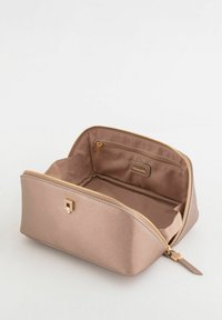 Beige kosmetiktaske med tekstureret yderside, gyldent lynlåslukning og lomme indvendigt. Kompakt rektangulær form, foret inderside.