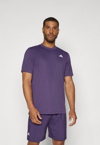 Purple athletic shirt and shorts made of lightweight fabric. The shirt features a round neckline and a small white logo on the chest.