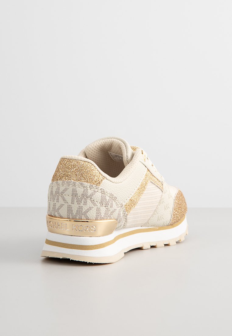 Baskets beige et dorées avec des accents pailletés, motif texturé MK, col rembourré et semelle blanche avec une bande dorée, vue angulaire depuis l'arrière.