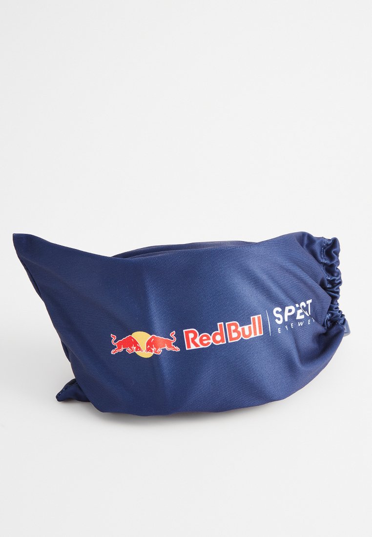 Granatowa saszetka wykonana z gładkiego materiału, z marszczonym górnym brzegiem. Prezentuje logo Red Bull oraz napis "SPET Eyewear" w białym i czerwonym druku.