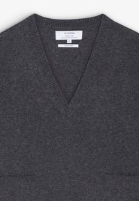 Pull col en V gris foncé avec col côtelé et petites poches avant, portant une étiquette de la marque Scalpers indiquant un fil italien et une taille small.