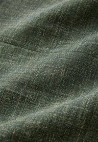 Tamsiai žalia audinio medžiaga, pasižyminti tekstūruotu audimu su įvairiomis atspalviais ir švelniu paviršiumi. Visame paviršiuje lengvas taškinis raštas.