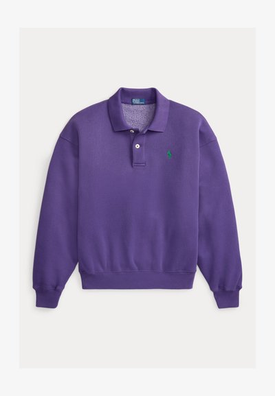 Μωβ βαμβακερό φούτερ με γιακά που διπλώνει, πατιλέτα με τρία κουμπιά και πράσινο λογότυπο στο αριστερό στήθος. Ριμπ μανσέτες και τελείωμα.