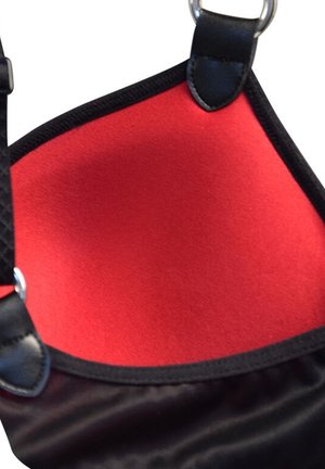 Sac en tissu noir avec un intérieur rouge, présentant une texture lisse, une forme rectangulaire et des accents en métal.