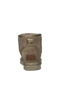 Beige suède enkelboot met een zachte voering, ronde neus en een gestructureerde achterkant. Voorzien van een leren label in bruin met het 'Warmbat' logo. Platte rubberen zool.