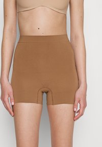 Bruine shapewear shorts met een gladde textuur, hoge tailleband en een snit tot halverwege de dij. Bevat versterkte stiksels en een ingebouwde slip-ontwerp.