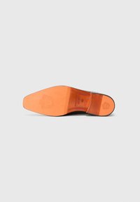 Black leather shoe sole featuring a smooth orange interior with textured accents and a detailed embossed logo near the heel.