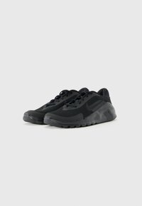 Et par sorte Nike Flex løbesko med mesh-overdel og gummisål, vist på en ensfarvet lys baggrund.