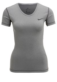 Haut de sport gris à manches courtes avec un col en V, fabriqué en matériau synthétique Dri-FIT, présentant des coutures sombres discrètes et un logo Nike sur la poitrine.