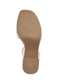 Sandal con tacco bianco dotato di una suola in gomma marrone texturizzata con un motivo geometrico e branding, cinturino alla caviglia regolabile e parte superiore liscia.