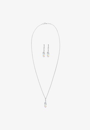 Zilveren ketting met een delicate schakel en een druppelvormige kristallen hanger; bijpassende oorbellen hebben een vergelijkbaar ontwerp met hangende kristallen.