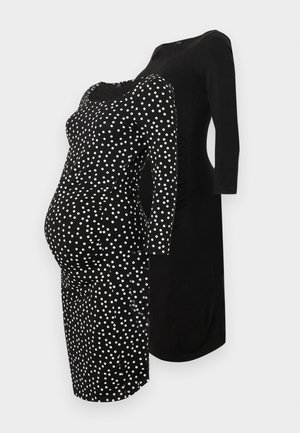 Abiti premaman neri: uno con pois bianchi e una forma aderente, l'altro interamente nero con un design rilassato e maniche a tre quarti.