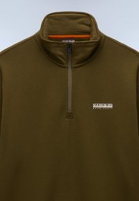 Oliwkowo-zielony polar z wysokim kołnierzem, półzamkiem z przodu oraz białym haftowanym logo na lewej piersi.