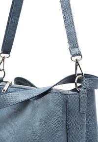 Modrá perforovaná kožená kabelka se zipovým uzávěrem, nastavitelným popruhem a stříbrnými kovovými akcenty. Hladká textura se strukturovaným tvarem.