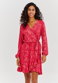 Červené zavinovací šaty s dlouhými rukávy, volánkovým lemem sukně a texturovaným vzorem v různých odstínech červené a růžové. Obsahují detail s bočním zavázáním.