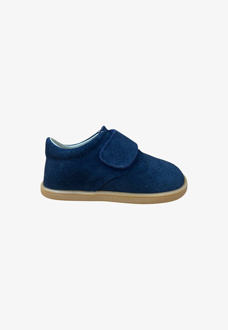 Zapato de ante azul marino para niños con suela de goma beige y cierre de único cinturón de velcro en un fondo blanco.